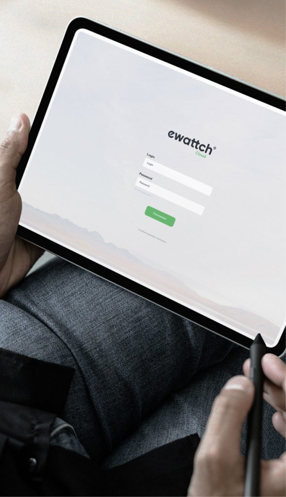 Utilisateur consultant l’écran de connexion Ewattch Cloud sur une tablette tactile, permettant un accès sécurisé aux tableaux de bord, alertes et données du bâtiment depuis un appareil mobile.