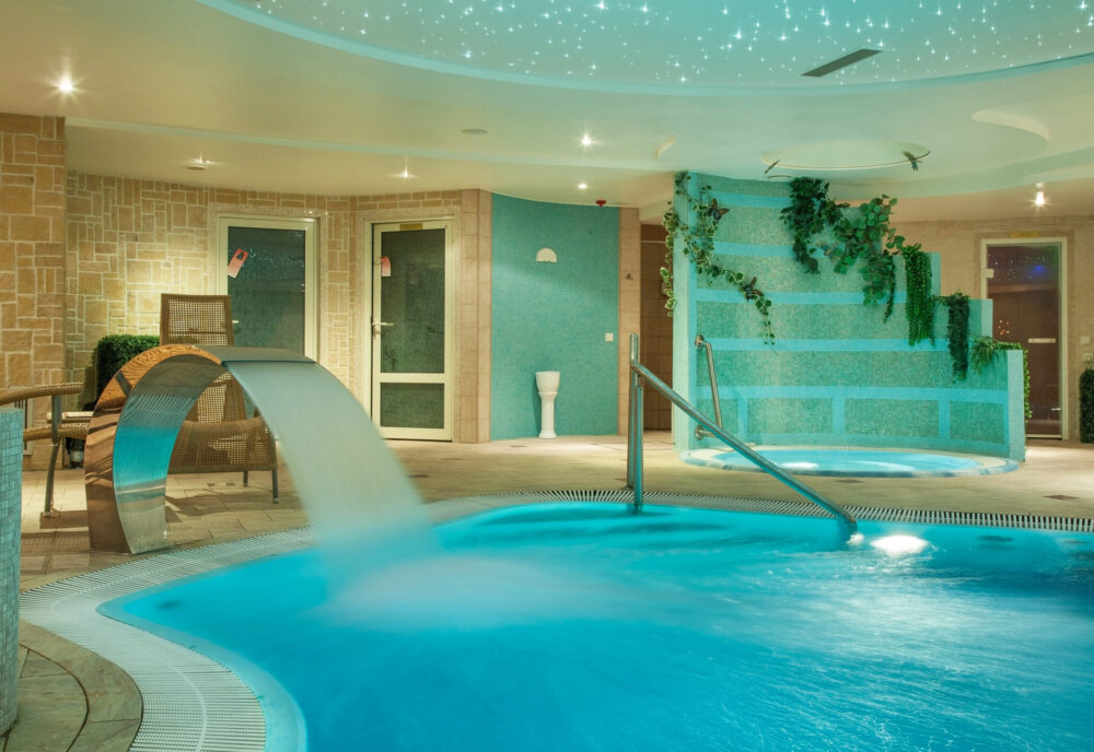 Spa d’hôtel avec piscine intérieure, jacuzzi et ambiance relaxante.
