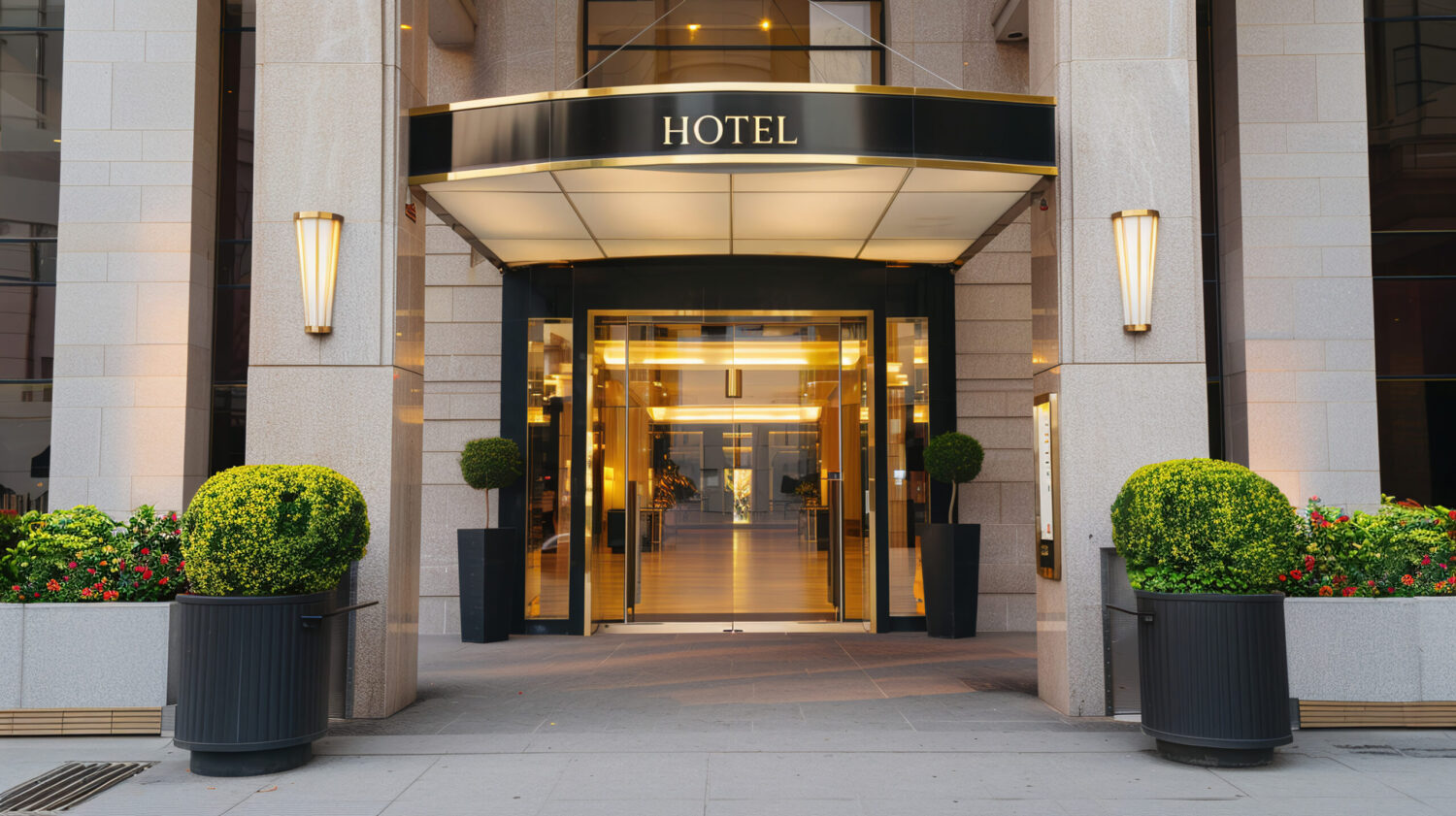 Façade et entrée principale d’un hôtel moderne avec hall lumineux et décoration soignée.