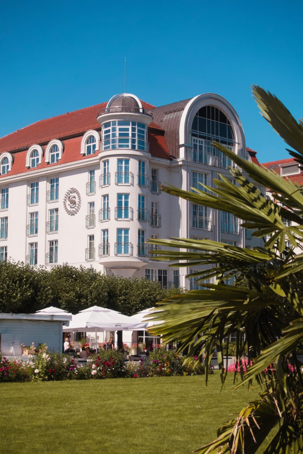 Vue extérieure d’un hôtel premium avec architecture élégante et jardin aménagé.