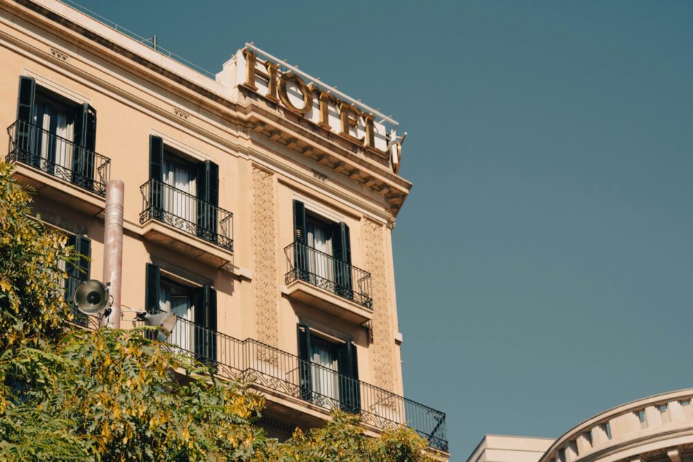 Façade élégante d’un hôtel avec enseigne visible, architecture haut de gamme et balcons en centre-ville.