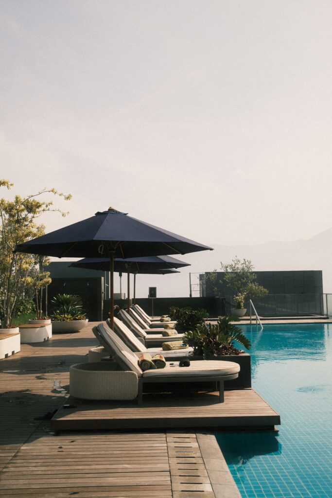 Piscine d'un hôtel avec transats et parasols.